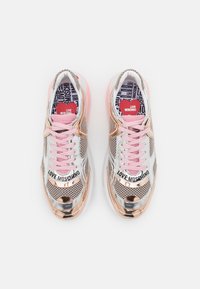 Stříbrné síťované tenisky s růžově zlatými akcenty a růžovou podrážkou. Obsahují branding "LOVE MOSCHINO" na jazyku a vzor uvnitř.