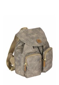 Sac à dos en tissu tissé beige et marron avec un rabat, deux poches zippées à l'avant, des bretelles réglables et des accents en cuir.