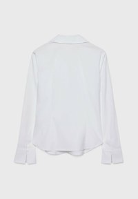 Chemise blanche à manches longues avec un col claudine, présentant un tissu texturé et des poignets boutonnés. Dos ajusté avec un ourlet légèrement incurvé.