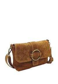 Sac bandoulière en daim marron de forme plate, avec un accent métallique circulaire sur le rabat et une sangle réglable. Texture lisse, design simple.