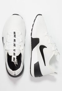 Valkoiset verkkomaiset urheilukengät mustilla yksityiskohdilla. Ominaisuuksiin kuuluvat musta kumipohja, kontrastivärit nauhat logolla sekä sulavalinjainen, moderni muotoilu.