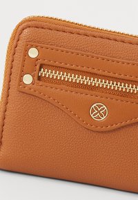 Brown leather wallet featuring a zippered pocket, gold hardware accents, textured surface, and a circular logo on the front.