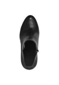 Bottine en cuir noire avec fermeture éclair latérale et bout arrondi, vue de dessus sur fond blanc.