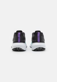 Zwarte sportieve schoenen met een gestructureerde mesh bovenkant, paarse accenten op de hiel en een witte tussenzool met een zwarte gestreepte buitenzool.