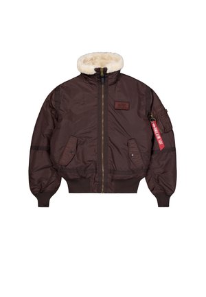 Chaqueta bomber marrón con un suave cuello de piel sintética, cierre de cremallera, dos bolsillos frontales y un bolsillo en el hombro con una etiqueta roja. Textura suave, diseño acolchado.