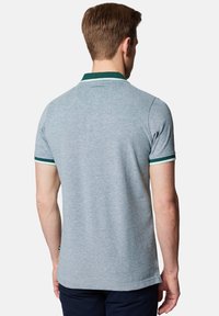 Szara koszulka polo z krótkimi rękawami, z zielono-białym paskiem wykończenia kołnierzyka, wykonana z przewiewnego materiału. Logo na tyle w okolicy szyi.