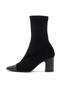 Bota negra hasta el tobillo hecha de un textil suave con una puntera de cuero liso. Presenta un tacón cuadrado y un diseño ceñido similar a un calcetín.