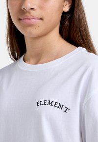 Witte katoenen T-shirt met een gebogen zwart "ELEMENT" logo boven de borst. Ronde hals, korte mouwen en een gladde textuur.