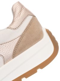 Nahaufnahme der Fersenseite eines Sneakers mit beigefarbenem Wildleder, metallic Leder, weißer Zwischensohle und brauner Gummiaußensohle mit strukturiertem Profil.