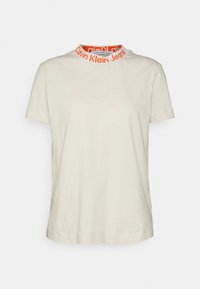 Off-white short-sleeve t-shirt with high collar featuring orange "Calvin Klein Jeans" text around neckline.