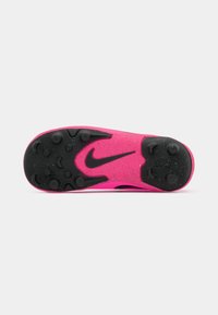 Semelle de chaussure de sport rose avec un extérieur en caoutchouc noir, dotée de picots moulés pour l'adhérence et d'un logo Nike noir contrastant.