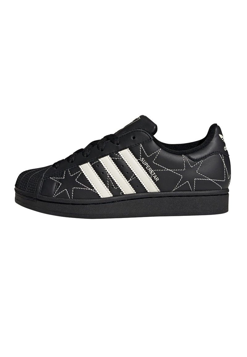 Black leather sneaker with white star patterns, three white stripes on the side, and a rubber toe cap. Lace-up design with a textured sole.