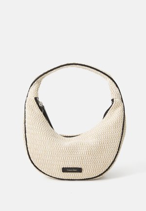 Sac à main tissé beige en forme de croissant avec bordure noire et logo Calvin Klein sur le devant, équipé d’une poignée unique et d’une fermeture éclair.
