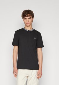 Lacoste CORE ACTIVE - Nyomott mintás póló - black
