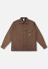 Smeđa košulja dugih rukava izrađena od mekog tkanja, s kopčanjem na dugmad sprijeda, džepom na prsima i svijetlosmeđim dugmadima. Ukrasni logo na džepu.