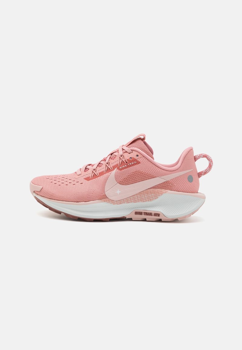 Chaussure de trail running Nike rose avec dessus en mesh, semelle intermédiaire blanche et languette au talon, vue de côté sur fond blanc.