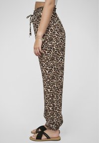 Leopardenmuster-Jogginghosen mit elastischem Bund und gebundenem Kordelzug. Leichter Stoff, schmaler Schnitt und geraffte Knöchelabschlüsse.