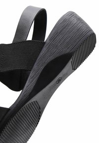 Infradito neri con suola in gomma testurizzata, ampie cinghie in tessuto e una soletta sagomata per il massimo comfort. Design elegante e minimalista.