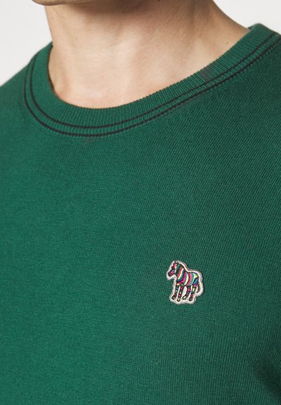 Green sweater with a ribbed neckline and contrasting black stitching. Features a multicolored, embroidered horse logo on the chest.