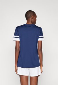 Marine sportsdrakt med hvite stripe detaljer på ermene, laget av glatt stoff, med rund hals og avslappet passform.
