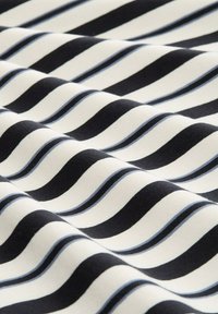 Baumwollstoff mit wellenförmigen Streifen in Schwarz, Weiß und Hellblau, der eine glatte Textur und ein fließendes Muster über das Material hinweg betont.
