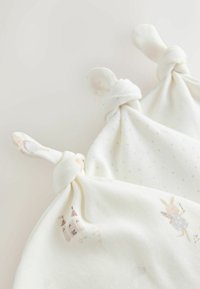 Accappatoi per neonati in cotone color crema, con angoli annodati. Uno presenta un motivo a pois delicato, l'altro mostra illustrazioni di animali.