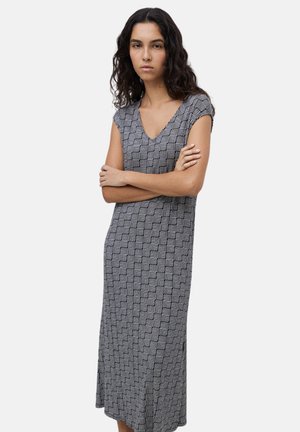 Vestido de patrón en blanco y negro, de longitud media, con escote en V y mangas cortas, que presenta un diseño geométrico y una sutil textura.