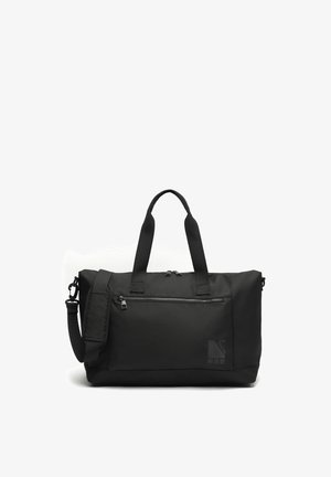 Bolsa de viaje negra con dos asas, correa de hombro desmontable, bolsillo frontal con cremallera y doble cremallera superior sobre fondo blanco.