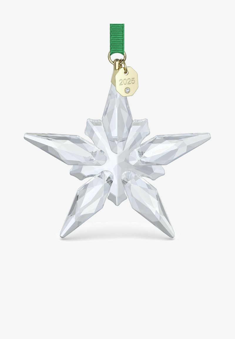 Ornamento a forma di stella di cristallo con punte appuntite e sfaccettate, trasparenza chiara, nastro verde attaccato e un'etichetta dorata con la scritta "2025".