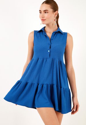 Blue sleeveless dress with a collared neckline, button details, flared skirt, and textured fabric. Features a tiered hem design.