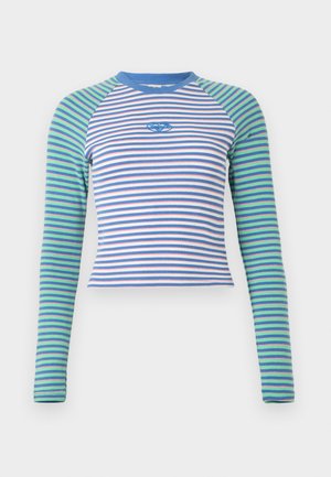 Pikad käisedega soonikkoes pluus, millel on kehaosa horisontaalsed sinised, valged ja roosad triibud, rohelised ja sinised triibulised varrukad ning keskel tikitud logo.