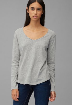 Grå langermet T-skjorte med V-hals, myk tekstur og rundkant. Brukt med mørke jeans, som viser et enkelt, uformelt design.