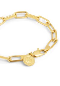 Pulsera de cadena en tono dorado con eslabones alargados, un encanto en forma de medallón decorativo y cierre de langosta. Acabado suave y pulido.