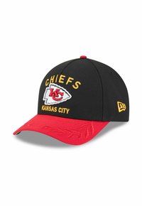 Schwarze Baseballmütze mit einem roten Schirm, auf dem "CHIEFS" und "KANSAS CITY" in gelber Stickerei zu sehen sind. Zeigt ein rot-weißes Team-Logo.