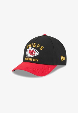 Black baseball cap with a red brim, featuring "CHIEFS" and "KANSAS CITY" in yellow embroidery. Displays a red and white team logo.