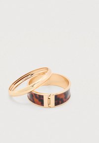 Du šaliai: vienas auksinis metalas su lygia danga, kitas - platus rudas žvynelis su metaline užsegimu.