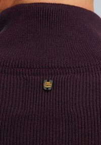Dunkellila gestrickter Pullover mit geribbelter Struktur. Auf der Rückseite des Kragens befindet sich ein kleines schwarzes und goldenes rechteckiges Etikett mit der Aufschrift "PME Legend".