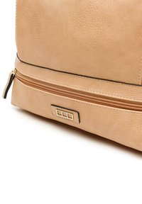 Šviesiai rudos spalvos odinė rankinė su tekstūruota paviršiumi, auksinės spalvos furnitūra ir užtrauktuko kišenė. Pasižymi elegantišku, struktūrizuotu dizainu.