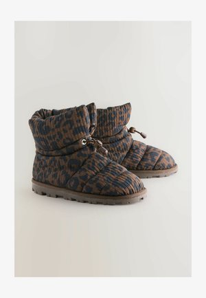 Pehmed pruunid ja tumesinised tickitud pahklinud saapad ümarate varvastega, mida hoiab kinni tõmblukk, ja millel on tekstuuriga talla parem haarduvus.