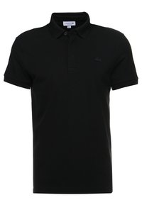 Černé polo tričko vyrobené z bavlny, s klasickým límečkem, krátkými rukávy a tonálním logem Lacoste na levé straně hrudi.