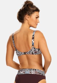 Komplet kostiumu kąpielowego składający się z biustonosza i majtek w wzory. Górna część posiada regulowane ramiączka oraz wielokolorowy wzór w ciemnych i jasnych odcieniach.