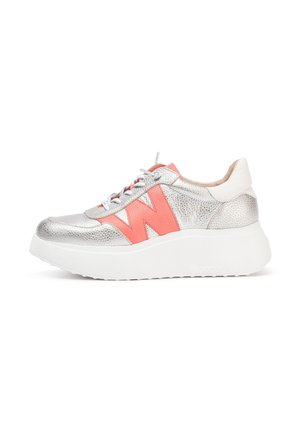 Baskets argentées métalliques avec une épaisse semelle blanche, mettant en avant un accent "W" corail audacieux et une finition texturée. Comprend des lacets blancs et un talon.