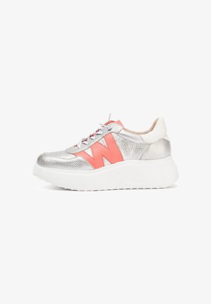 Zapatilla metálica plateada con una suela blanca gruesa, que presenta un acento coral en forma de "W" y un acabado texturizado. Incluye cordones y talón blancos.