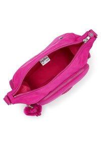 Pink fabric bag with a zipper, featuring a soft interior lining and a pom-pom accent. The brand label is visible inside.