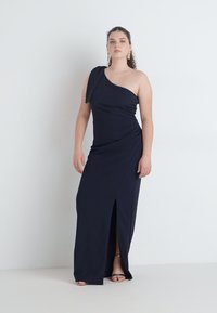 One-shoulder navy dress with draped fabric, a thigh-high slit, and a fitted silhouette. Smooth texture and minimalist design.