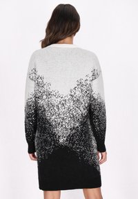 Rochie-pulover lungă cu un model în degradé de la gri deschis la negru, având embellishments pe umeri și manșete negre ribbate.