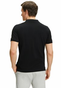 Czarna, krótko rękawowa koszulka polo o slim fit, wykonana z gładkiego, lekkiego materiału, z klasycznym kołnierzykiem i prostym dołem.