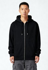 Felpa nera con zip, dotata di tasca frontale, cappuccio regolabile con cordini e polsini a coste. Realizzata in tessuto morbido con una texture liscia.