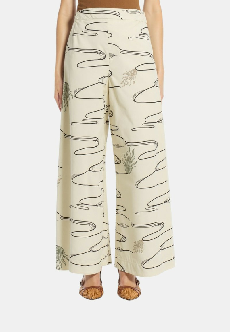 Pantaloni in cotone a gamba larga di colore beige chiaro, con motivi astratti a linee nere e dettagli verdi, caratterizzati da una texture liscia e una cintura elastica.