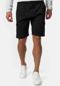 Schwarze Cargo-Shorts mit legerem Schnitt, ausgestattet mit Seitentaschen und einem Knopfverschluss. Hergestellt aus leichtem Material, mit einem sauberen Saum.